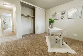 An office with a white rug and a desk with a sliding door